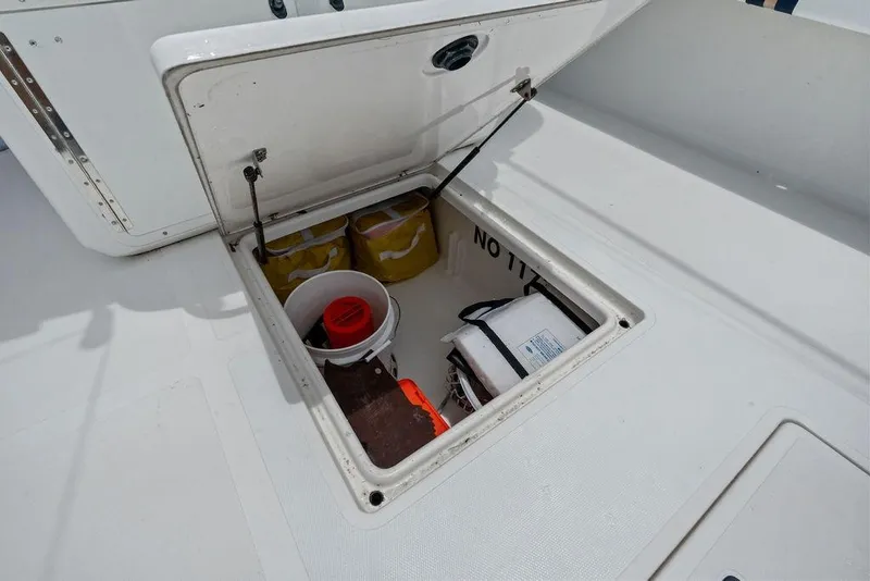 Slide: The Image of Open storage compartment on 1997 Venture 34 Center Console boat with safety equipment. - 31