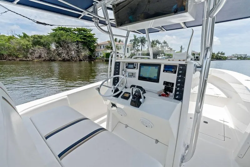Slide: The Image of 1997 Venture 34 Center Console boat interior with navigation equipment on a calm waterway. - 33