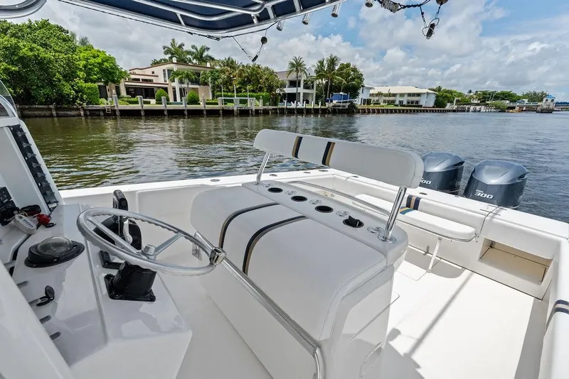 Slide: The Image of 1997 Venture 34 Center Console boat with dual engines, docked near waterfront homes. - 36