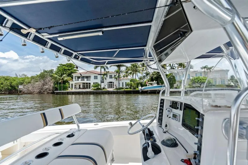 Slide: The Image of 1997 Venture 34 Center Console boat on a scenic waterfront, featuring a modern helm and canopy. - 39
