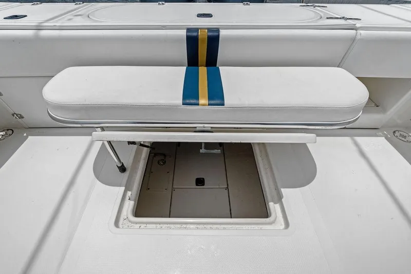 Slide: The Image of 1997 Venture 34 Center Console boat seat with storage compartment, featuring blue and gold stripe. - 45