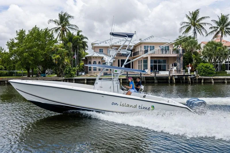Slide: The Image of 1997 Venture 34 Center Console boat cruising near waterfront homes with palm trees. - 5