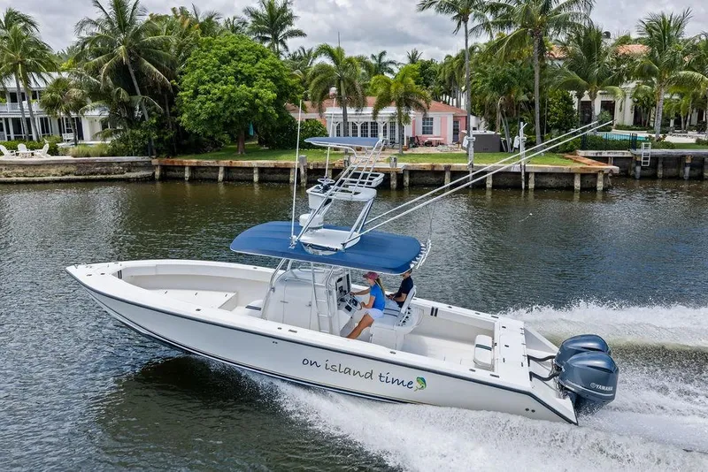Slide: The Image of 1997 Venture 34 Center Console boat cruising on a scenic waterway with palm trees. - 6