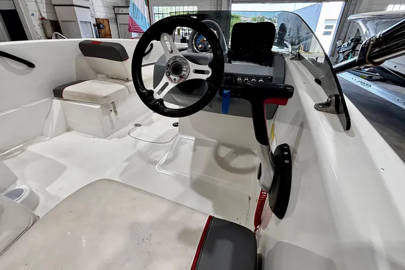 Slide: The Image of Interior of a 2020 Tahoe T16 boat, featuring steering wheel and seating. - 10