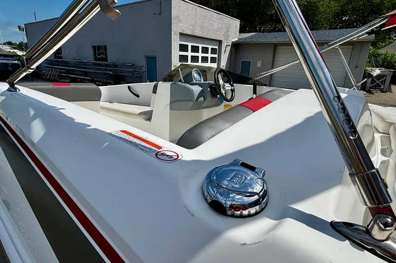 Slide: The Image of 2020 Tahoe T16 boat interior with steering wheel and seating, parked outdoors. - 12