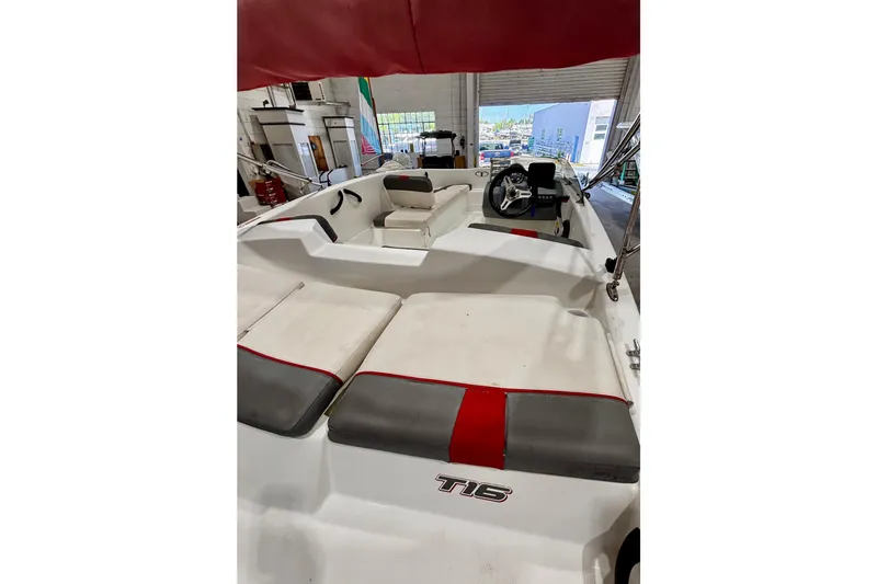 Slide: The Image of 2020 Tahoe T16 boat interior with red and gray seating, steering wheel visible. - 13