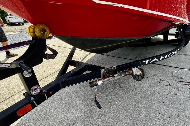 Slide: The Image of Red 2020 Tahoe T16 boat on trailer, parked on concrete surface. - 5