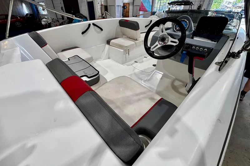 Slide: The Image of 2020 Tahoe T16 boat interior with steering wheel and seating in a garage setting. - 9