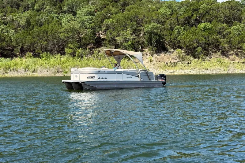 Slide: The Image of 2017 Avalon Catalina Platinum 2585 pontoon boat on a scenic lake with lush greenery. - 14