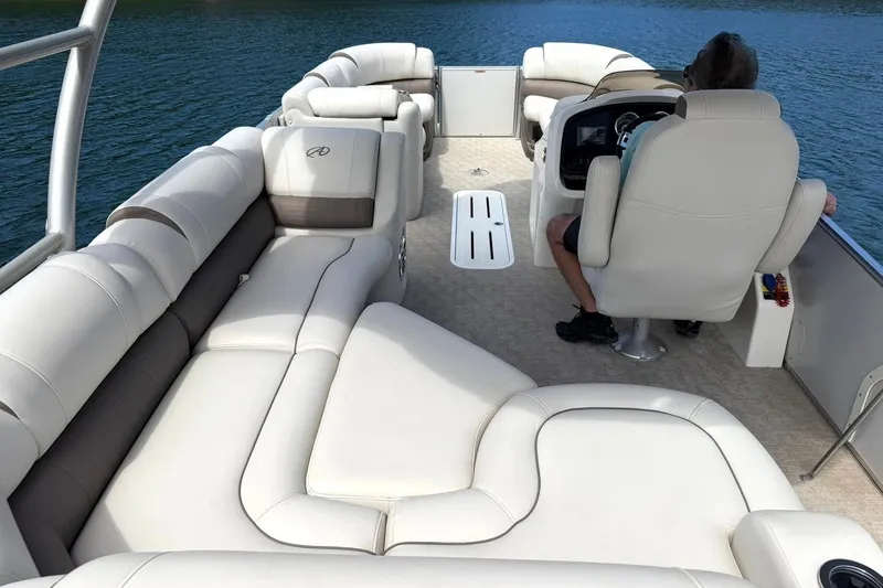Slide: The Image of 2017 Avalon Catalina Platinum 2585 pontoon boat interior with luxurious seating on a lake. - 2