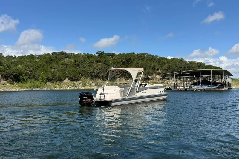 Slide: The Image of 2017 Avalon Catalina Platinum 2585 pontoon boat on a scenic lake with lush greenery. - 21