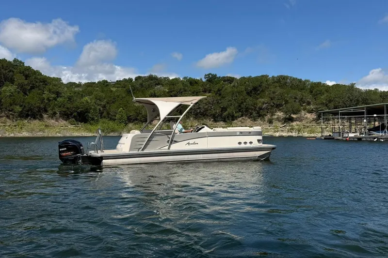 Slide: The Image of 2017 Avalon Catalina Platinum 2585 pontoon boat on a scenic lake. - 22