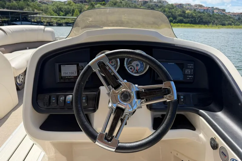 Slide: The Image of Steering console of 2017 Avalon Catalina Platinum 2585 pontoon boat on a scenic lake. - 32