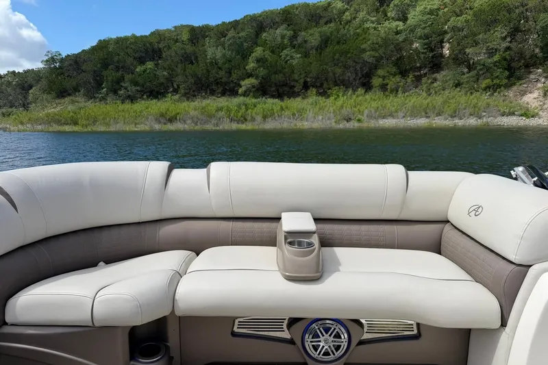 Slide: The Image of 2017 Avalon Catalina Platinum 2585 boat interior with plush seating, cup holder, and scenic lake view. - 36