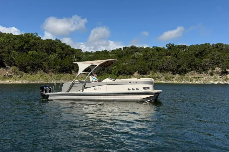 Slide: The Image of 2017 Avalon Catalina Platinum 2585 pontoon boat on a scenic lake with lush greenery. - 5