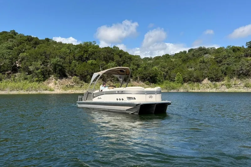 Slide: The Image of 2017 Avalon Catalina Platinum 2585 pontoon boat on a scenic lake with lush greenery. - 9