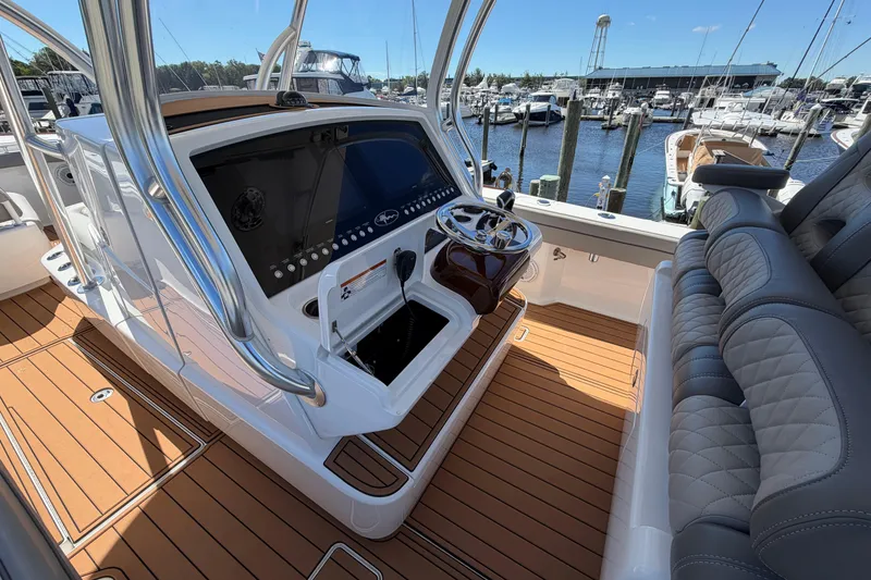 Slide: The Image of 2021 Valhalla Boatworks V-33 helm with modern controls and luxurious seating at a marina. - 14