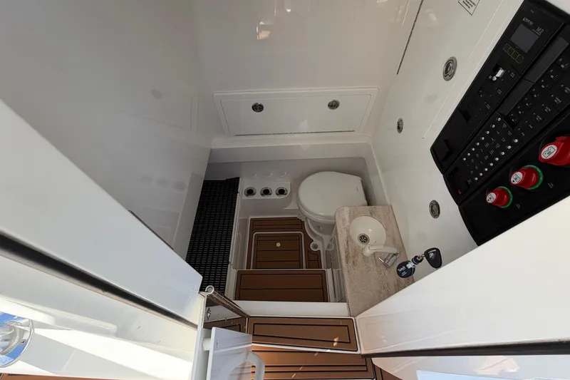 Slide: The Image of Interior of 2021 Valhalla Boatworks V-33 featuring a compact bathroom with sink and control panel. - 30