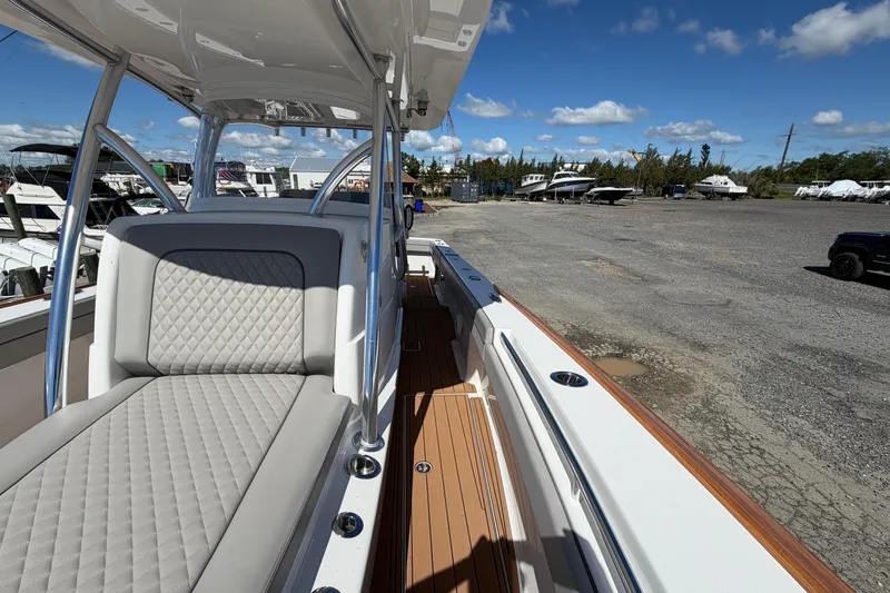 Slide: The Image of 2021 Valhalla Boatworks V-33 with sleek seating and deck, parked in a marina. - 6