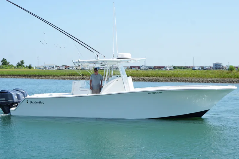 Slide: The Image of 2015 Onslow Bay boat on water with dual Yamaha engines, clear sky background. - 10