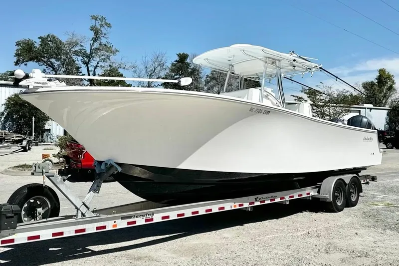 Slide: The Image of 2015 Onslow Bay boat on trailer, parked outdoors under clear sky. - 11