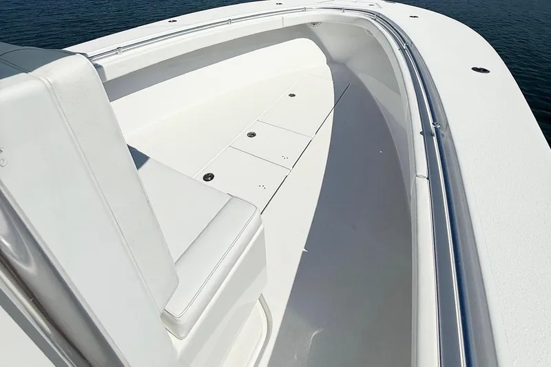 Slide: The Image of 2015 Onslow Bay boat interior with white seating and sleek design on calm water. - 14