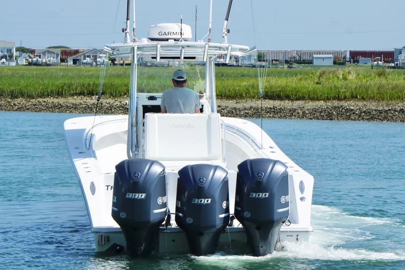 Slide: The Image of A 2015 Onslow Bay boat with triple Yamaha 300 engines cruising on water. - 3