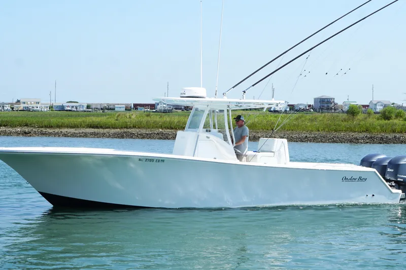 Slide: The Image of 2015 Onslow Bay boat cruising on calm water near a coastal town. - 9