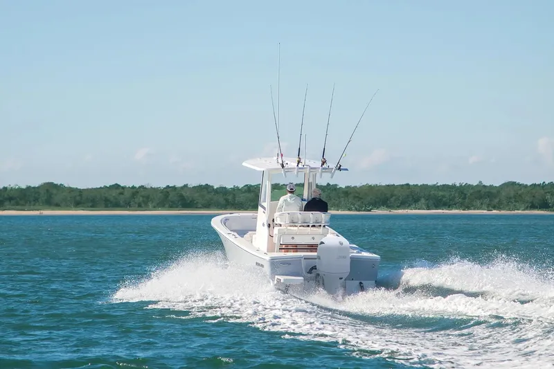 Slide: The Image of 2027 Regulator 24XO boat cruising on open water with fishing rods. - 1