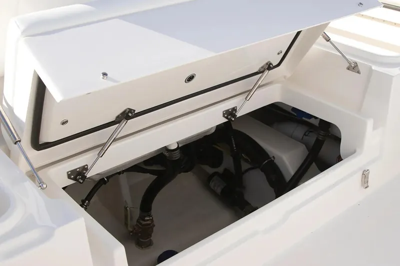 Slide: The Image of Open storage compartment on 2027 Regulator 24XO boat, showcasing internal components and wiring. - 6