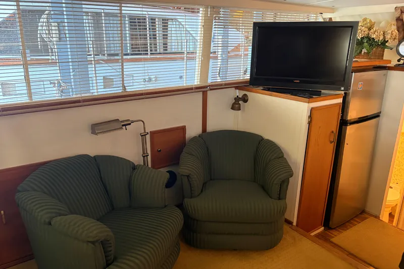 Slide: The Image of Interior of 1971 Chris-Craft 42 Commander with green chairs, TV, and mini fridge. - 17