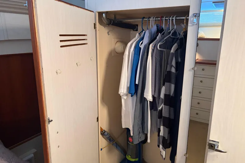Slide: The Image of Wardrobe inside 1971 Chris-Craft 42 Commander yacht, featuring hanging clothes and a vacuum cleaner. - 29