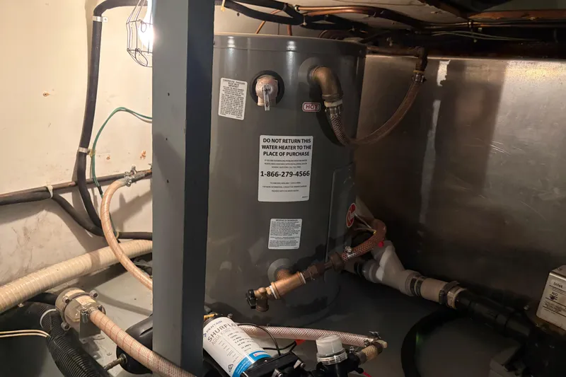 Slide: The Image of Water heater in 1971 Chris-Craft 42 Commander engine room, surrounded by pipes and wiring. - 32