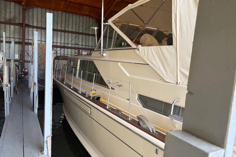 Slide: The Image of 1971 Chris-Craft 42 Commander yacht docked in a covered marina. - 5