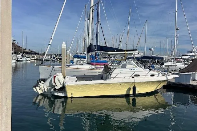 Slide: The Image of 1998 Pro-Line 2610 Walkaround boat docked in a marina with sailboats. - 3