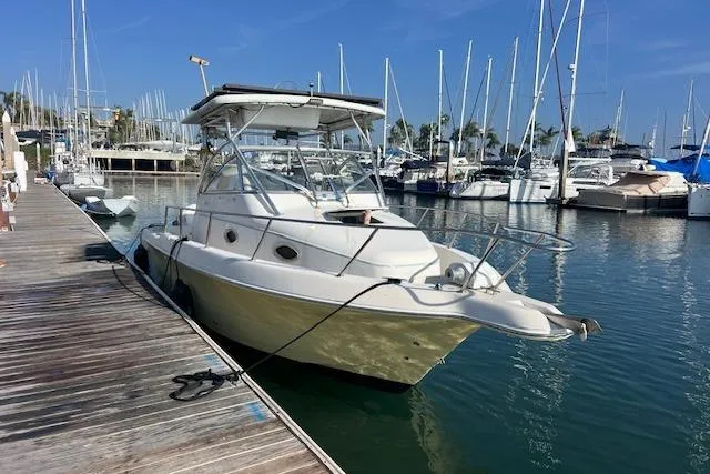 Slide: The Image of 1998 Pro-Line 2610 Walkaround boat docked in a marina with sailboats. - 4
