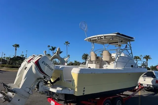 Slide: The Image of 1998 Pro-Line 2610 Walkaround boat with Evinrude motor on trailer, parked outdoors. - 30