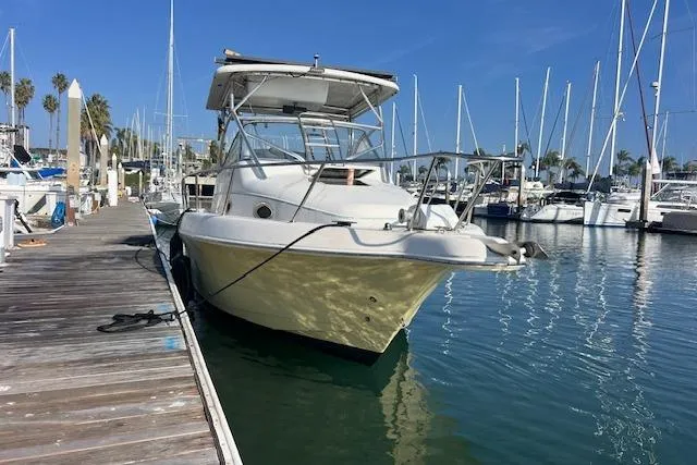 Slide: The Image of 1998 Pro-Line 2610 Walkaround boat docked at a marina with sailboats. - 5