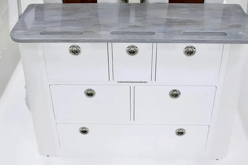 Slide: The Image of 2027 Regulator 30XO boat storage unit with sleek white drawers and metallic handles. - 16