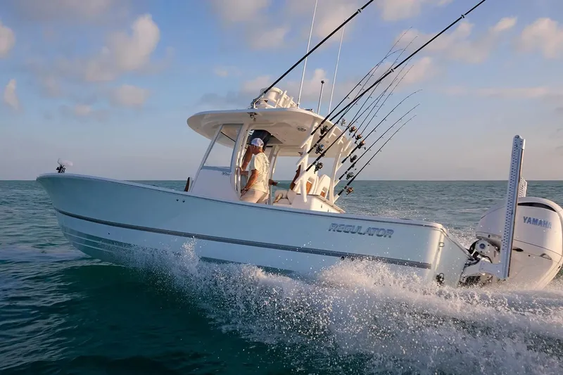 Slide: The Image of 2027 Regulator 30XO boat cruising on ocean with fishing rods and Yamaha engine. - 2