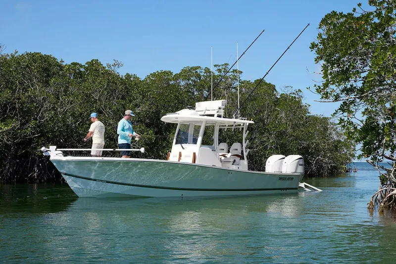 Slide: The Image of 2027 Regulator 30XO boat with anglers fishing in a serene mangrove setting. - 5
