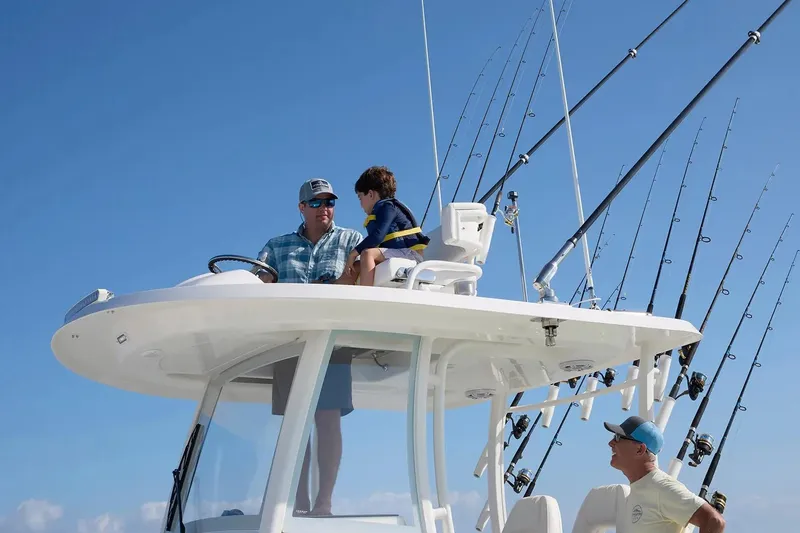 Slide: The Image of Family enjoying a day on a 2027 Regulator 30XO boat, surrounded by fishing rods. - 6