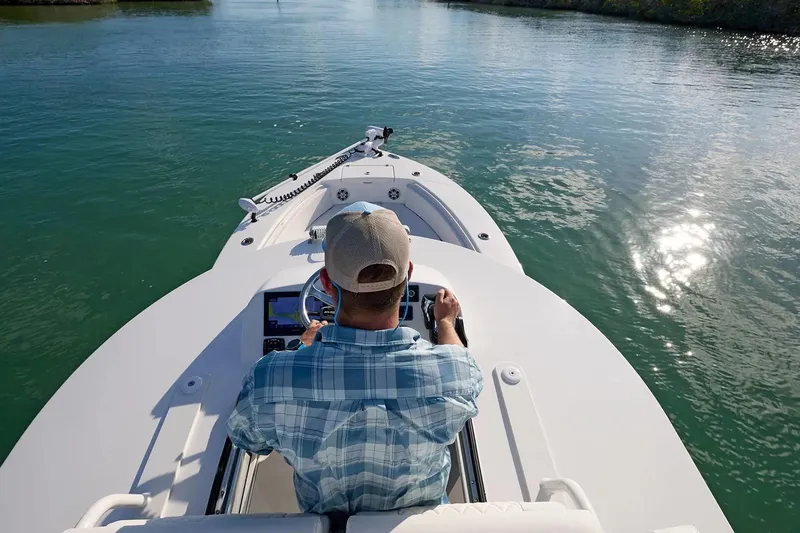 Slide: The Image of Man steering 2027 Regulator 30XO boat on calm water, sunny day. - 7