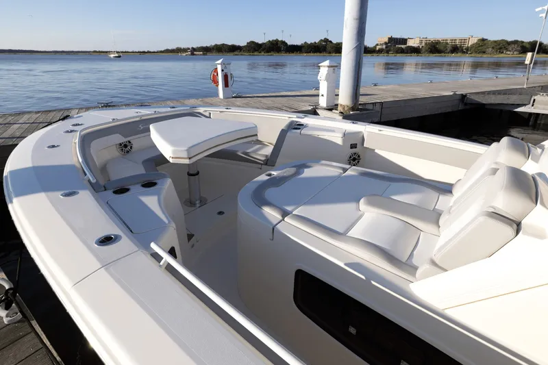 Slide: The Image of Scout 357 LXF 2027: Sleek design with comfortable seating and table, docked by calm waters. - 10