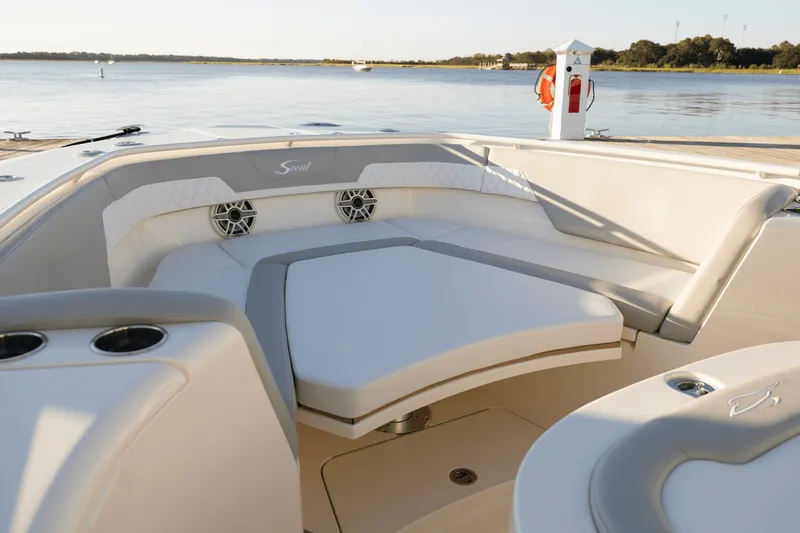 Slide: The Image of Scout 357 LXF 2027: Luxurious seating area with elegant upholstery and cup holders, docked by the water. - 16