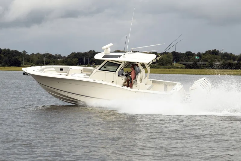 Slide: The Image of A 2027 Scout 357 LXF boat speeds across the water, surrounded by green landscape. - 7