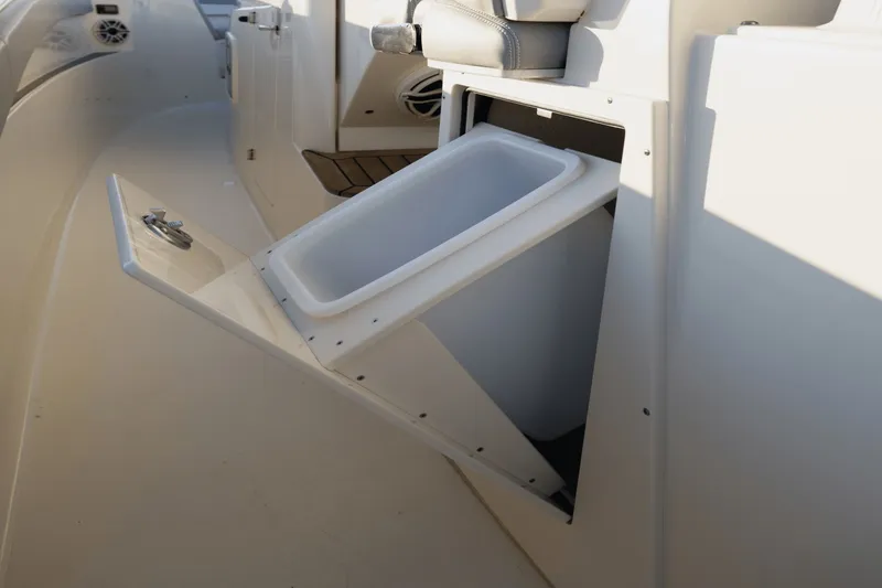 Slide: The Image of An open storage compartment with a removable bin on a Scout 357 LXF boat. - 33
