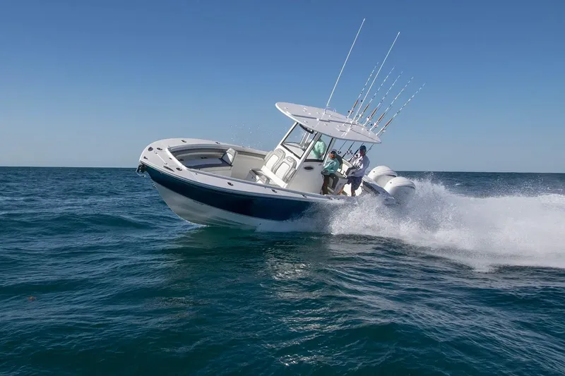 Slide: The Image of 2027 Regulator 25 boat speeding on open ocean, showcasing fishing rods and powerful engines. - 1