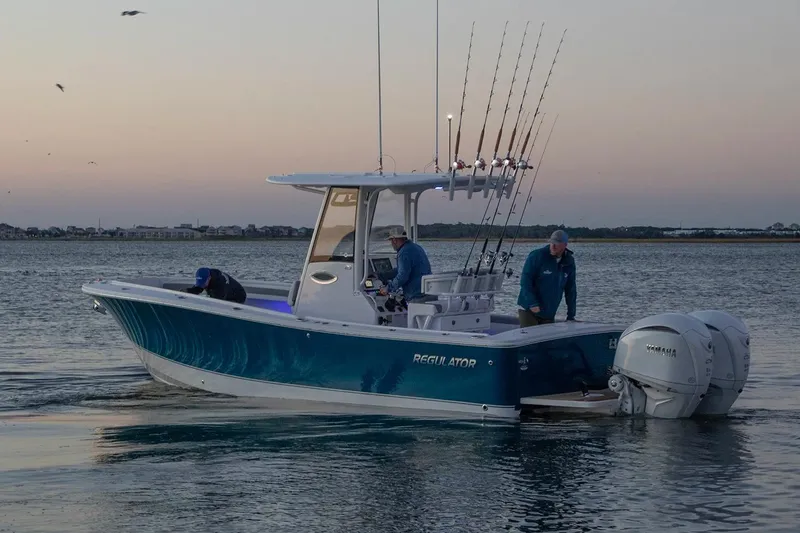 Slide: The Image of 2027 Regulator 25 boat with fishing rods at sunset on calm water. - 10