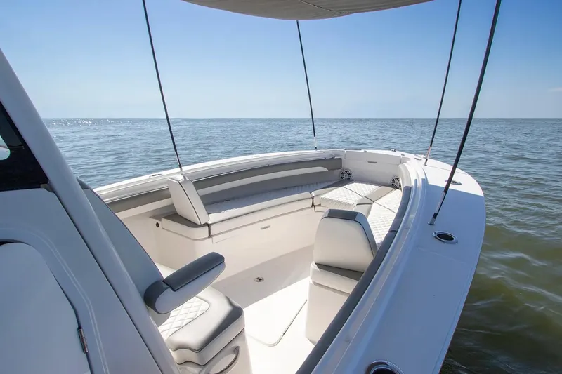 Slide: The Image of 2027 Regulator 25 boat interior with seating, ocean view, and clear sky. - 4